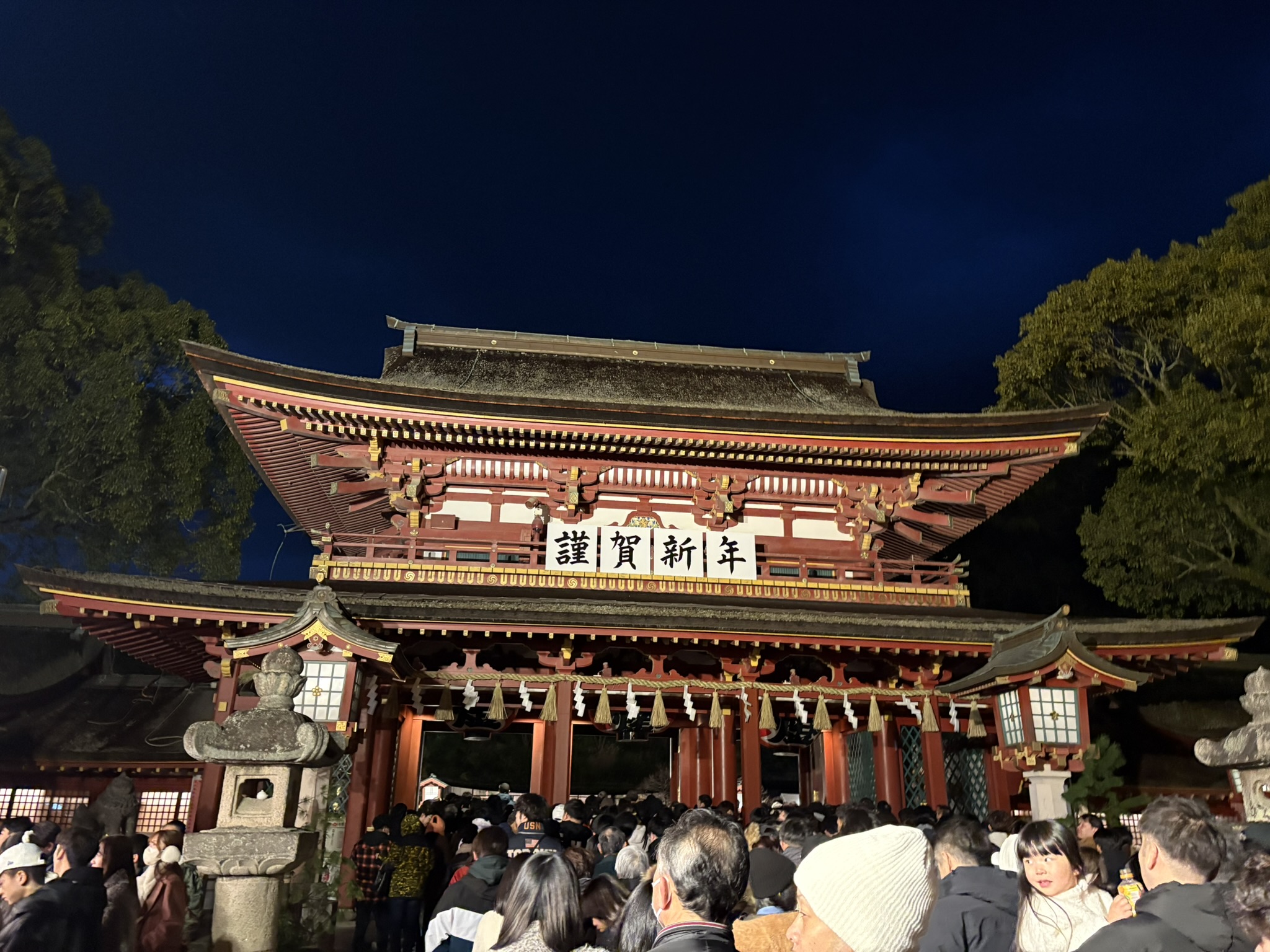 「謹賀新年」の掲示がある太宰府天満宮の楼門と初詣の人々
