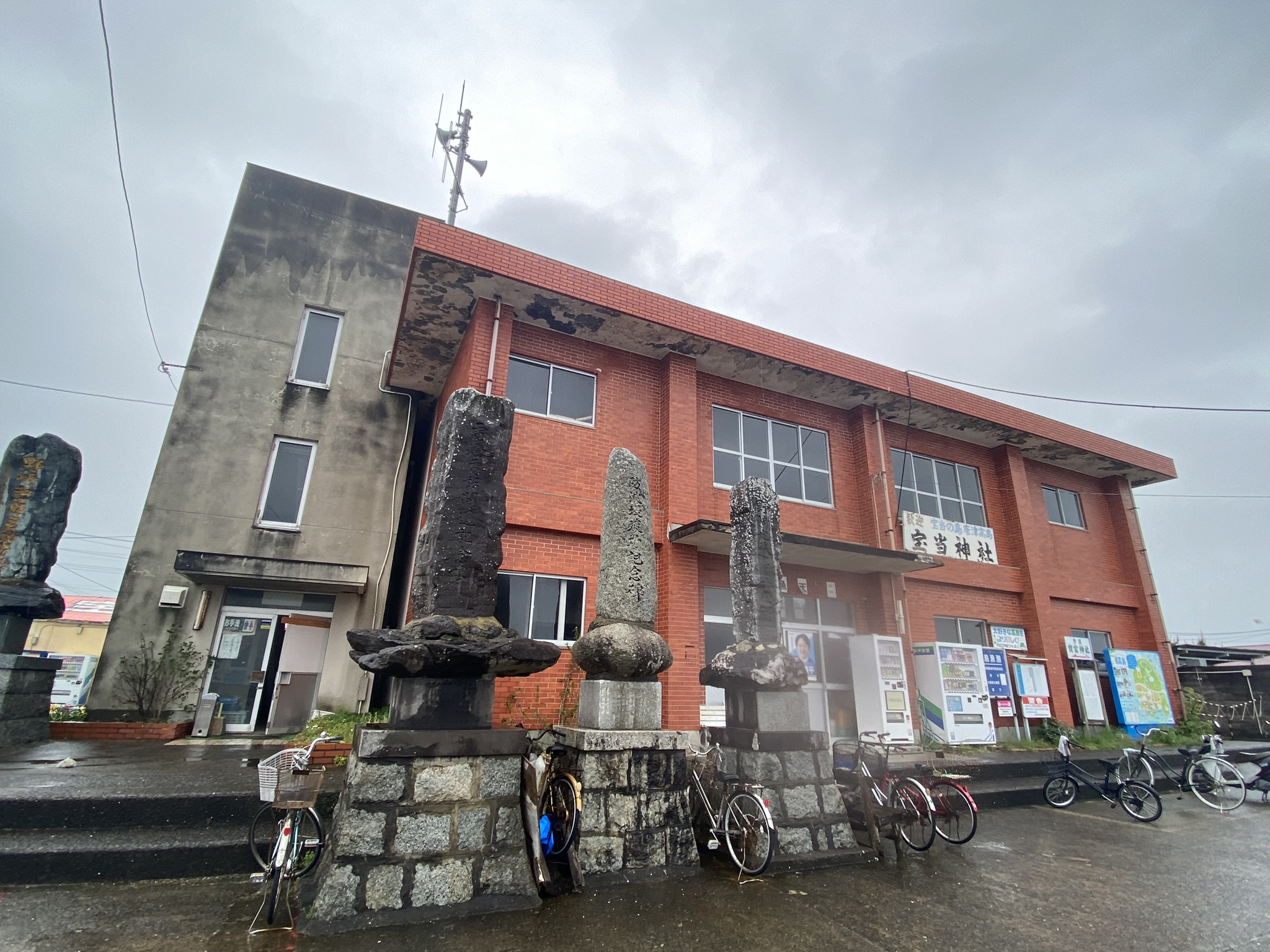Hodoto Shrine building on Takashima island with stone monuments and bicycles