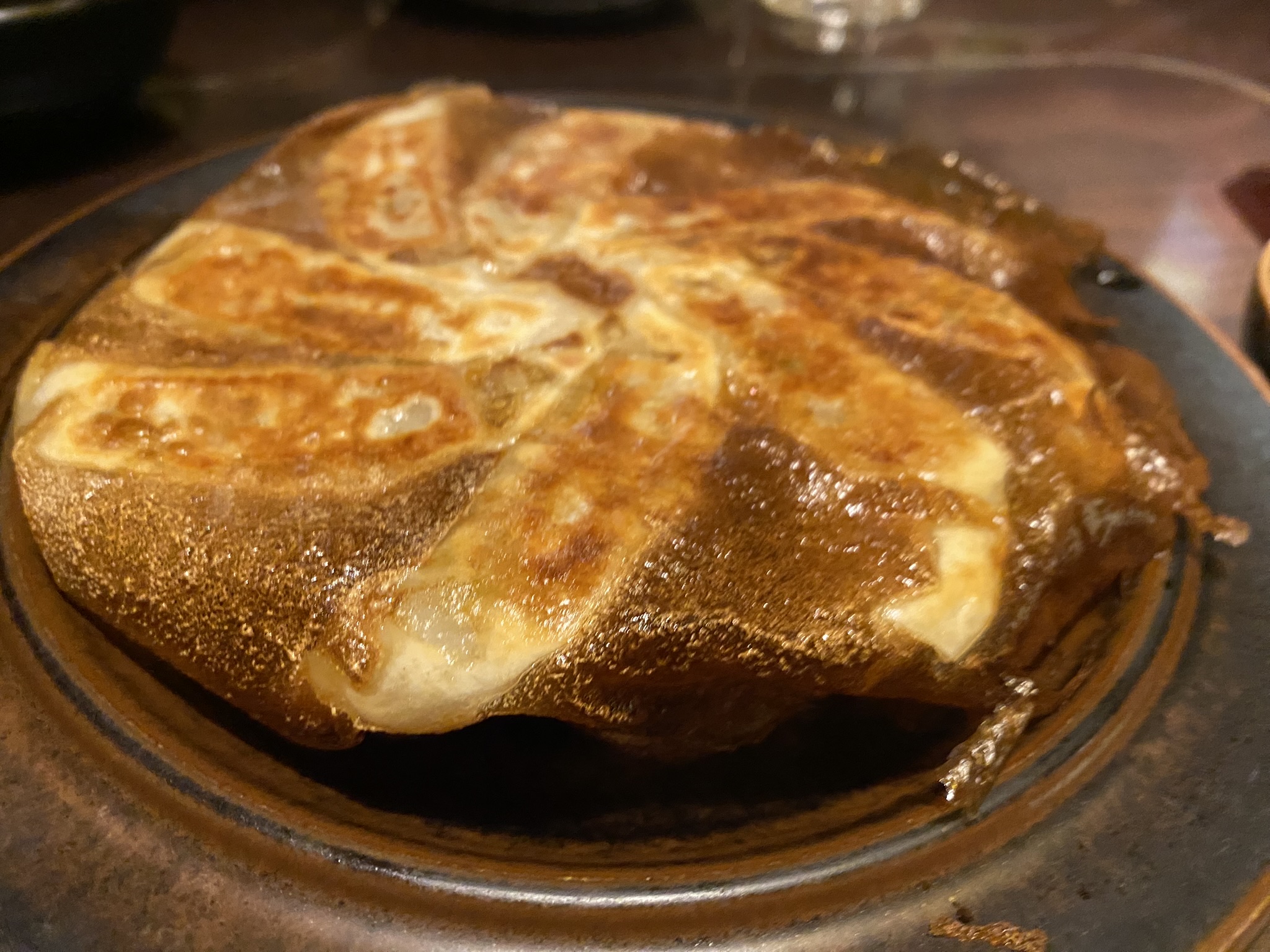 博多郷いさみの鉄鍋餃子。大きな鉄製の丸皿に餃子が環状に並んで焼かれている