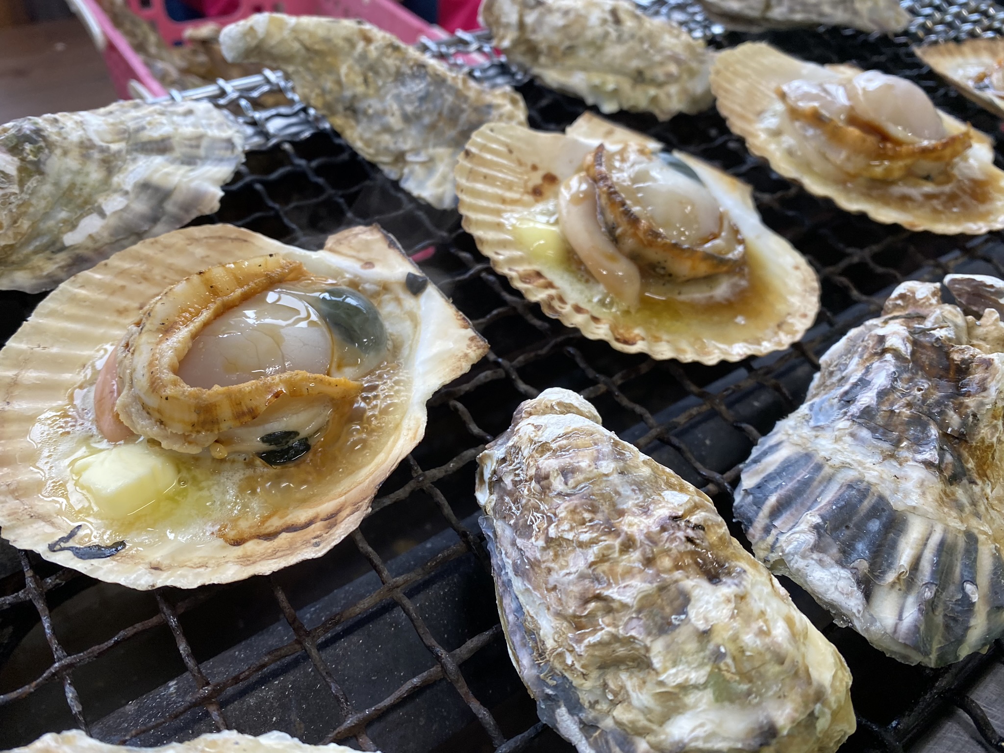 牡蠣とホタテがバターと一緒に焼かれているところ