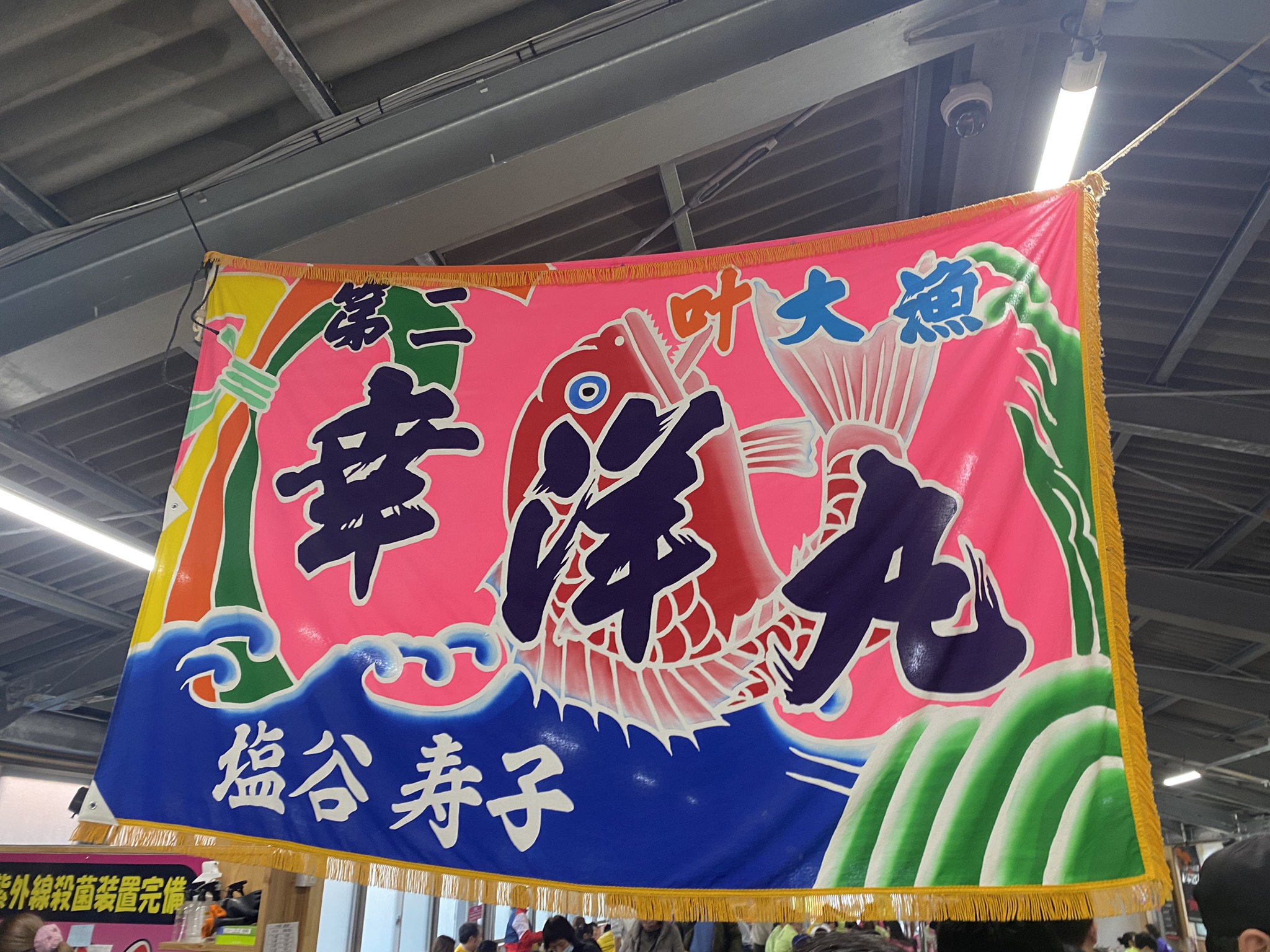 幸洋丸の大漁旗。色鮮やかな絵と「大魚 幸洋丸 塩谷寿子」の文字