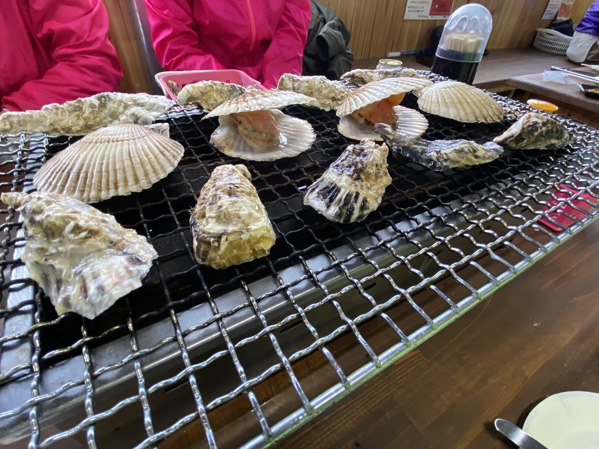 糸島の牡蠣小屋。鉄板の上に牡蠣とホタテが並んで焼かれている