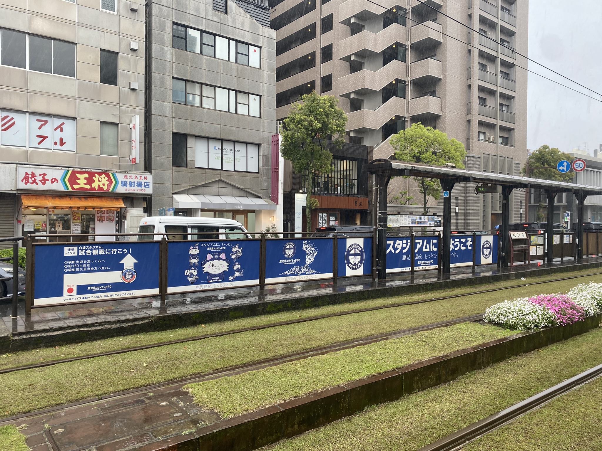 Kagoshima tram stop with welcome to stadium banner Kagoshima United FC promotion