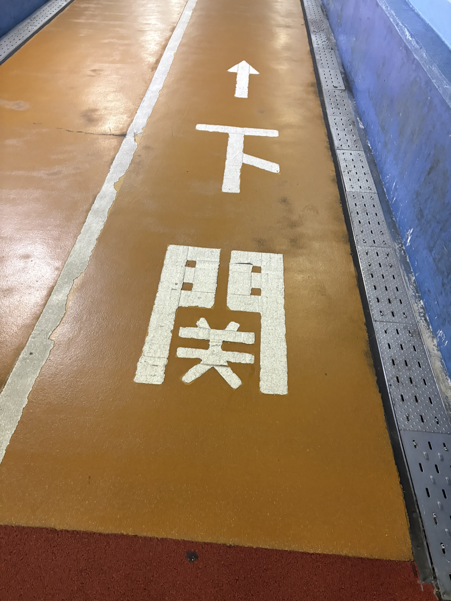 トンネルの床に書かれた「下関」の文字と進行方向の矢印