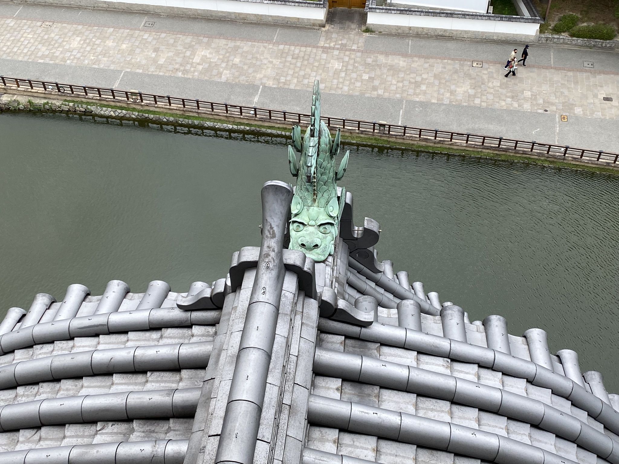 Kokura Castle top floor view tile roof gargoyle onigawara moat river below stone wall