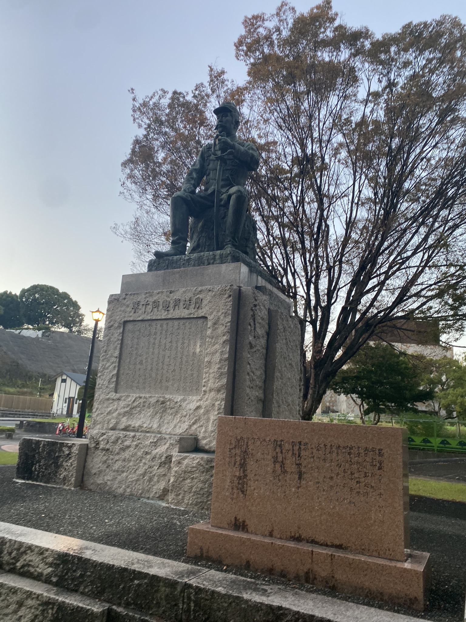 Bronze statue of a Edo period official or daimyo near Kumamoto Castle in evening light
