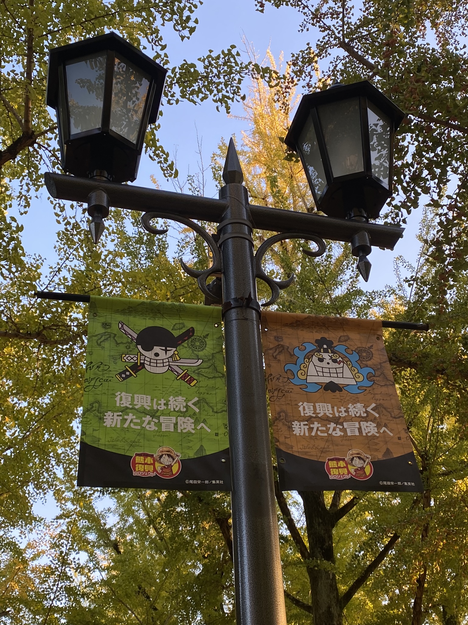 One Piece skull flag banner with text fukko wa tsuzuku new adventure in Kumamoto recovery project