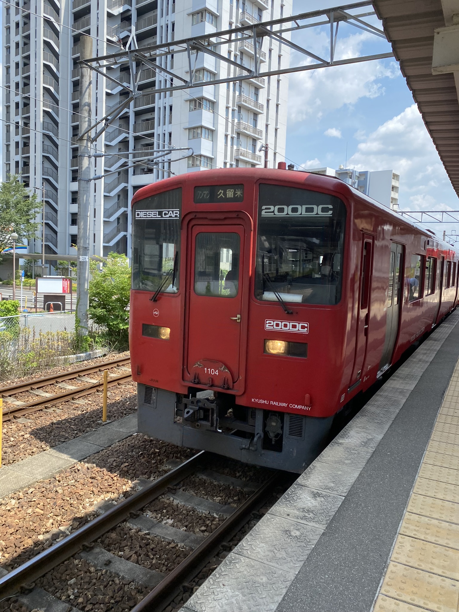 Red diesel train 200DC of Kyudai Line at a station platform