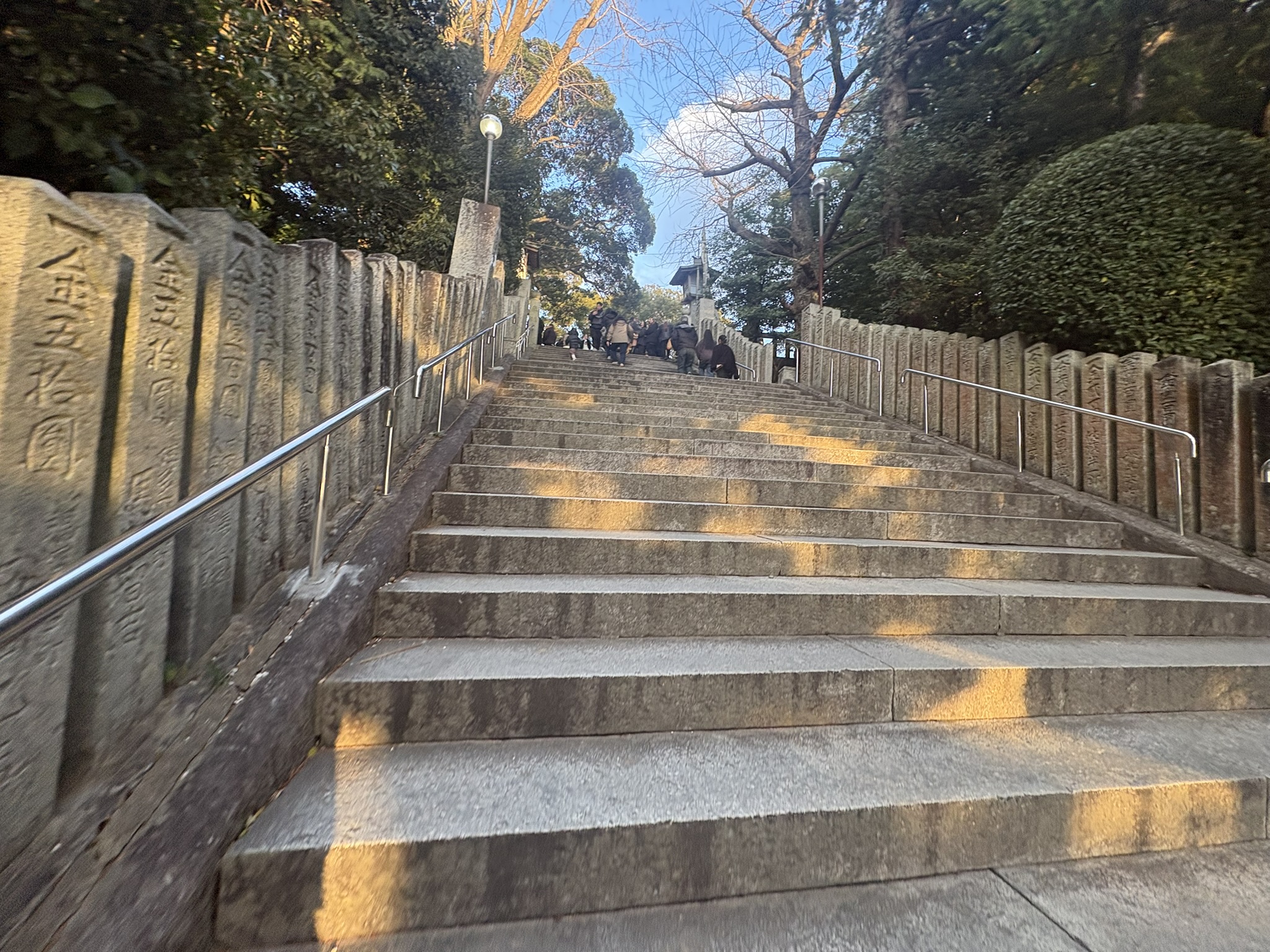Miyajidake Jinja stone steps approach lined with stone monuments winter morning sunlight