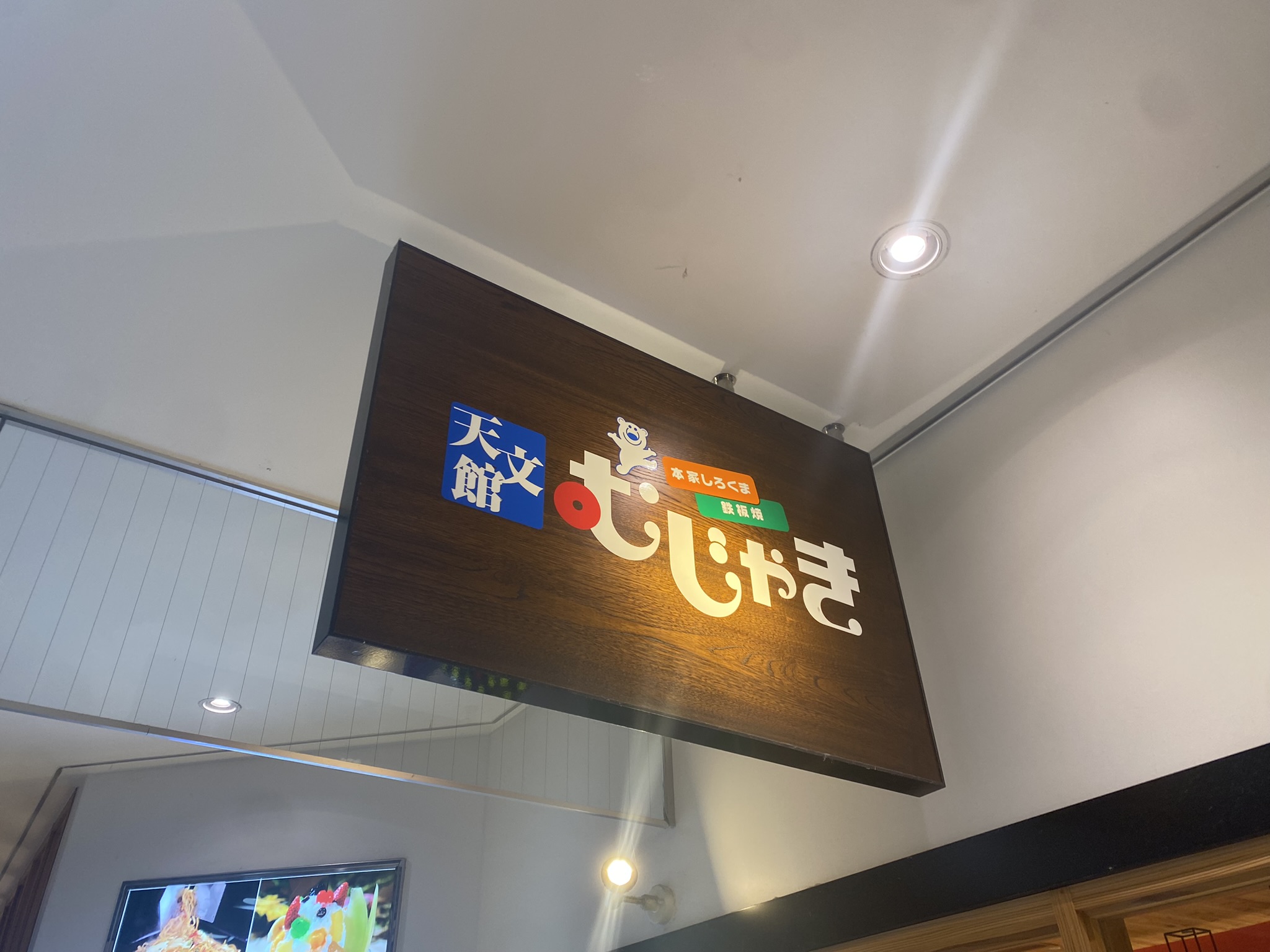 天文館むじゃきの吊り看板。「天文館 むじゃき」の文字と白熊マスコット