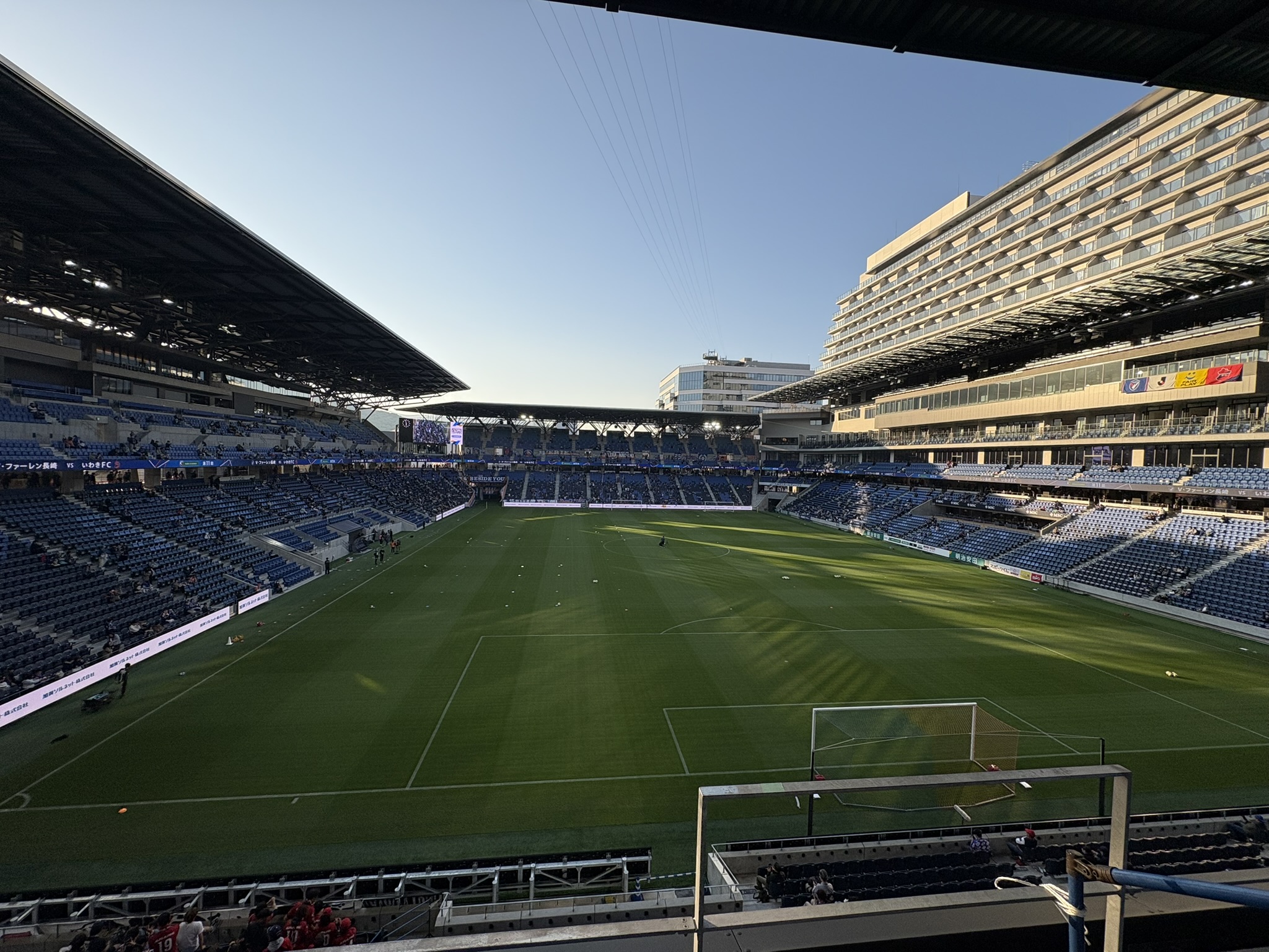PEACE STADIUM pitch wide view before match with hotel tower visible behind stands Nagasaki
