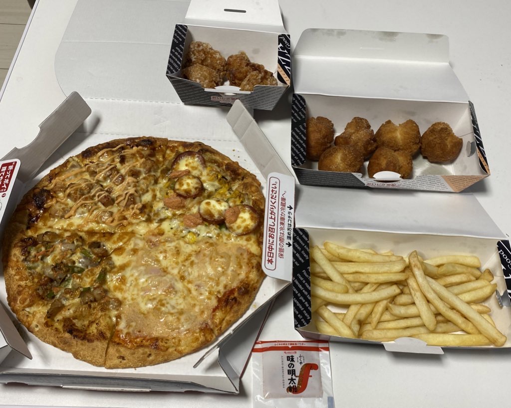 ピザクックのデリバリーボックス。ピザ＋チキン＋フライドポテトが届いている。明太ソースの小袋も付いている