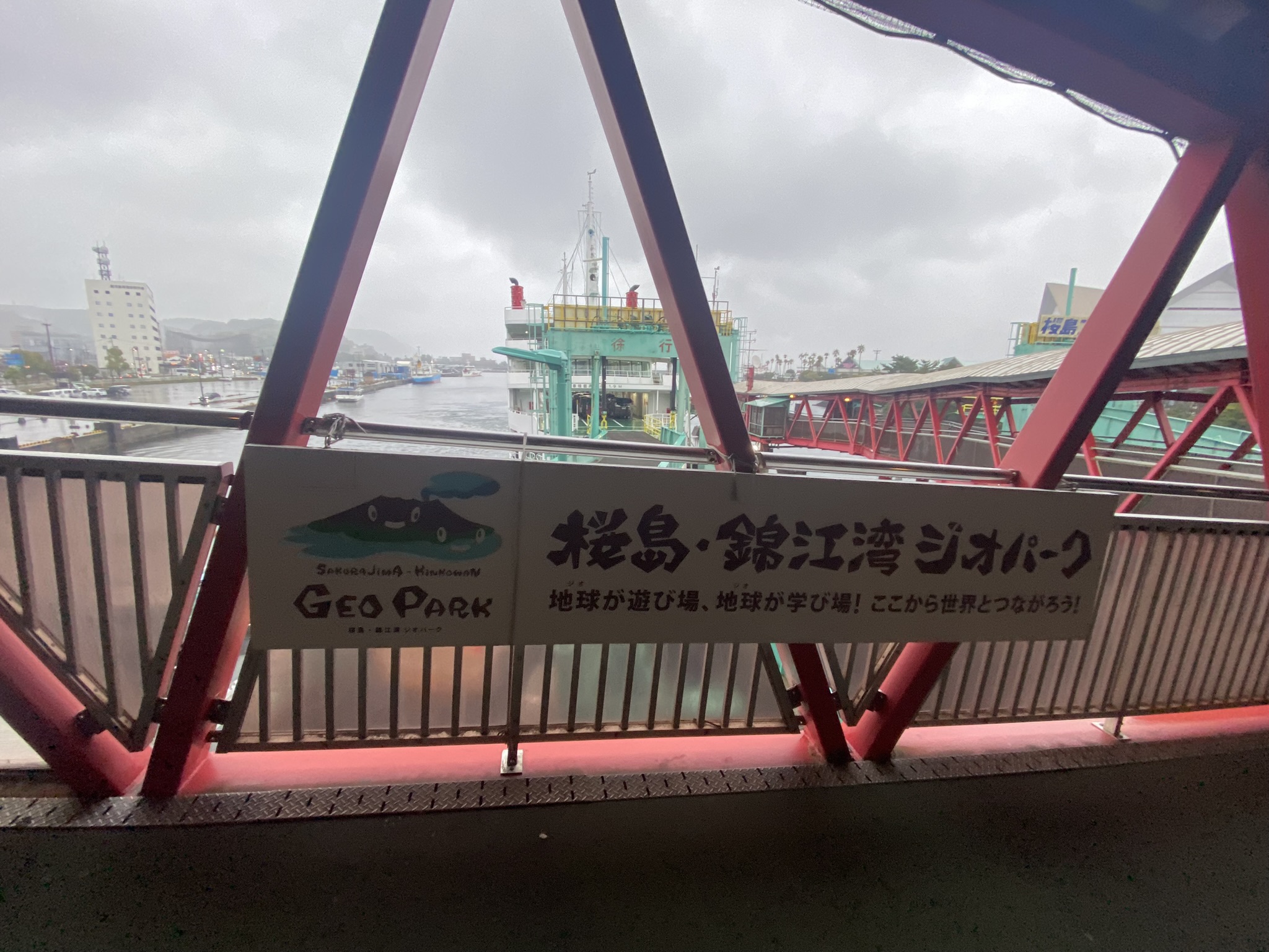 Sakurajima Kinkowan Geopark sign at ferry terminal Kagoshima red steel frame