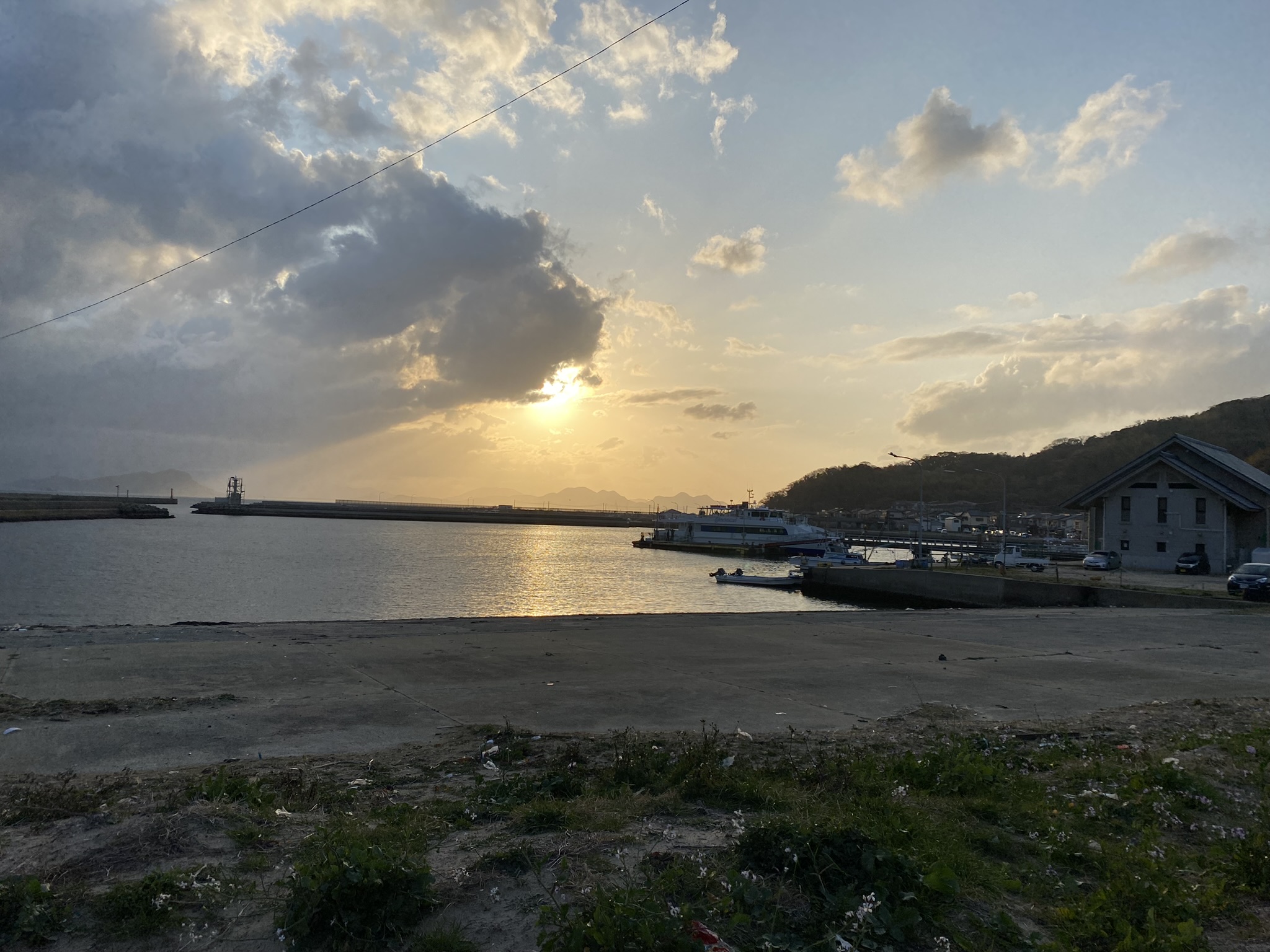 Shikanoshima island fishing port harbor boats sunset golden sky evening glow calm sea