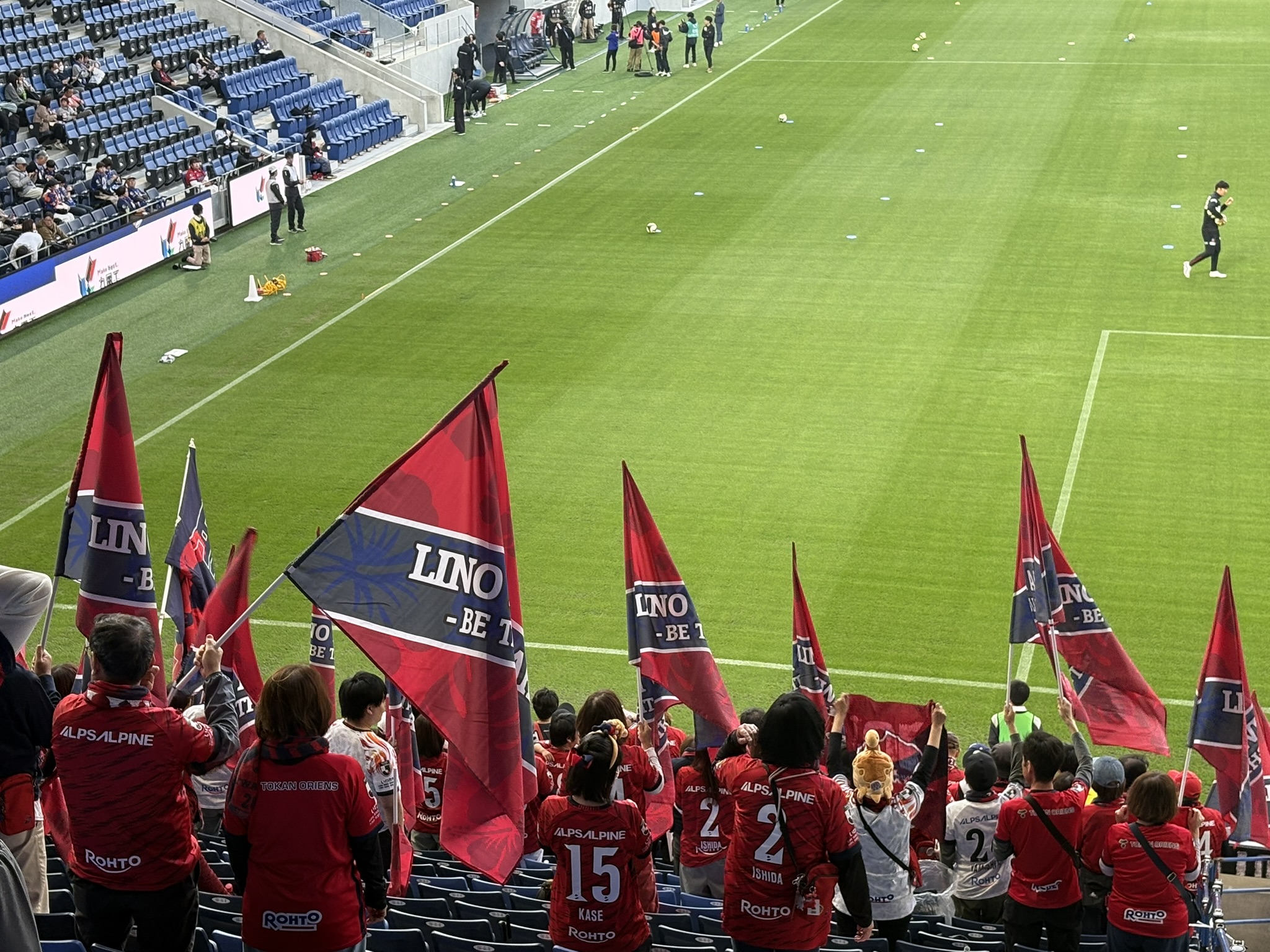 V-Varen Nagasaki supporters in red jersey holding LINO flags at PEACE STADIUM match